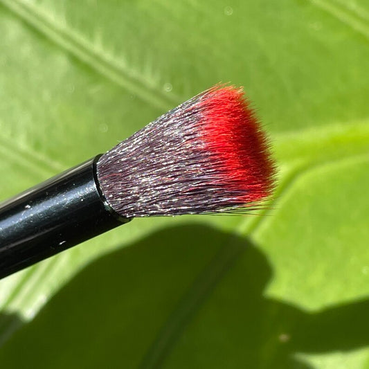Glass makeup brush with glow in the dark eye and red suckers.