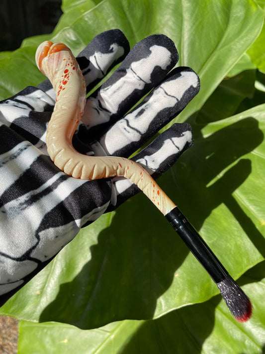 Glass makeup brush with glow in the dark eye and carved ventral scales.